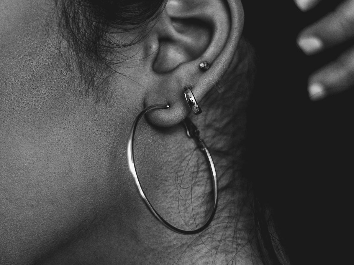 grayscale photo of woman with silver hoop earrings
