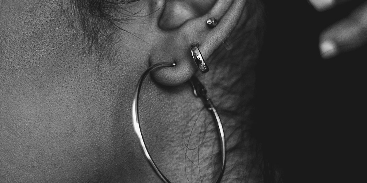 a close up of a person wearing a pair of earrings