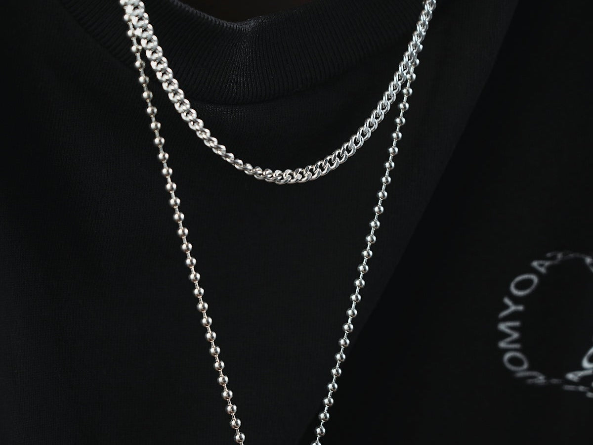 a man wearing a black shirt and a silver chain necklace