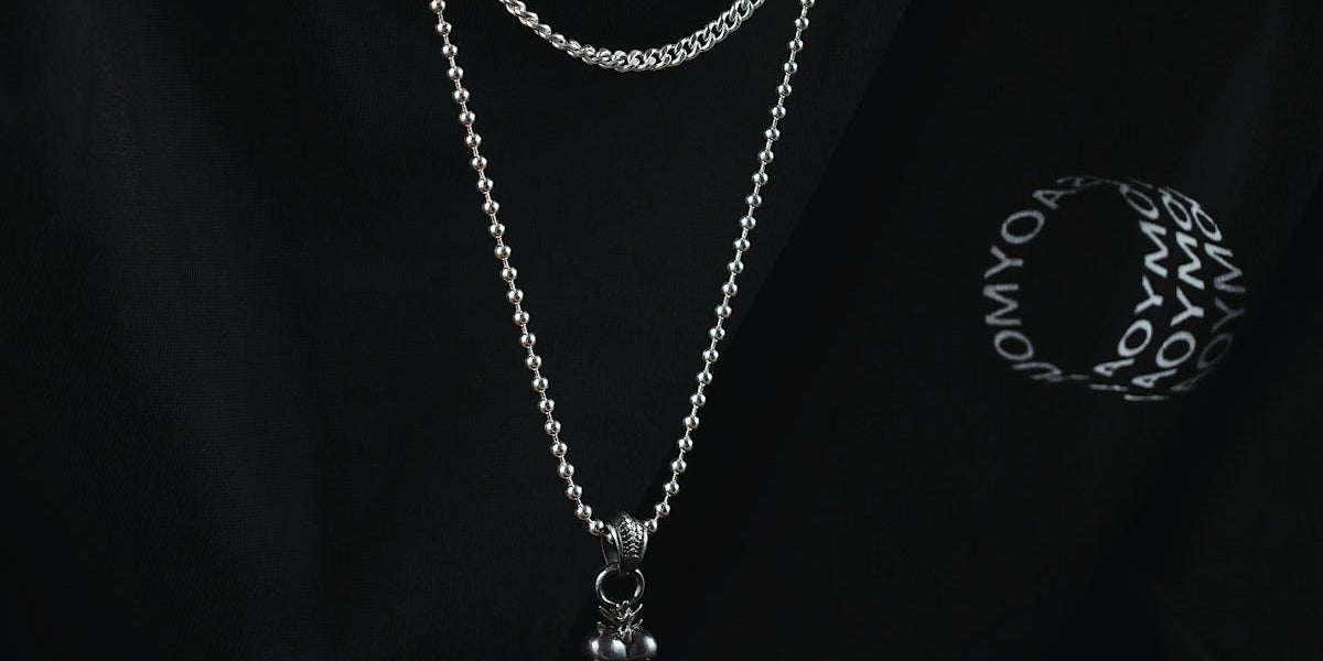 a man wearing a black shirt and a silver chain