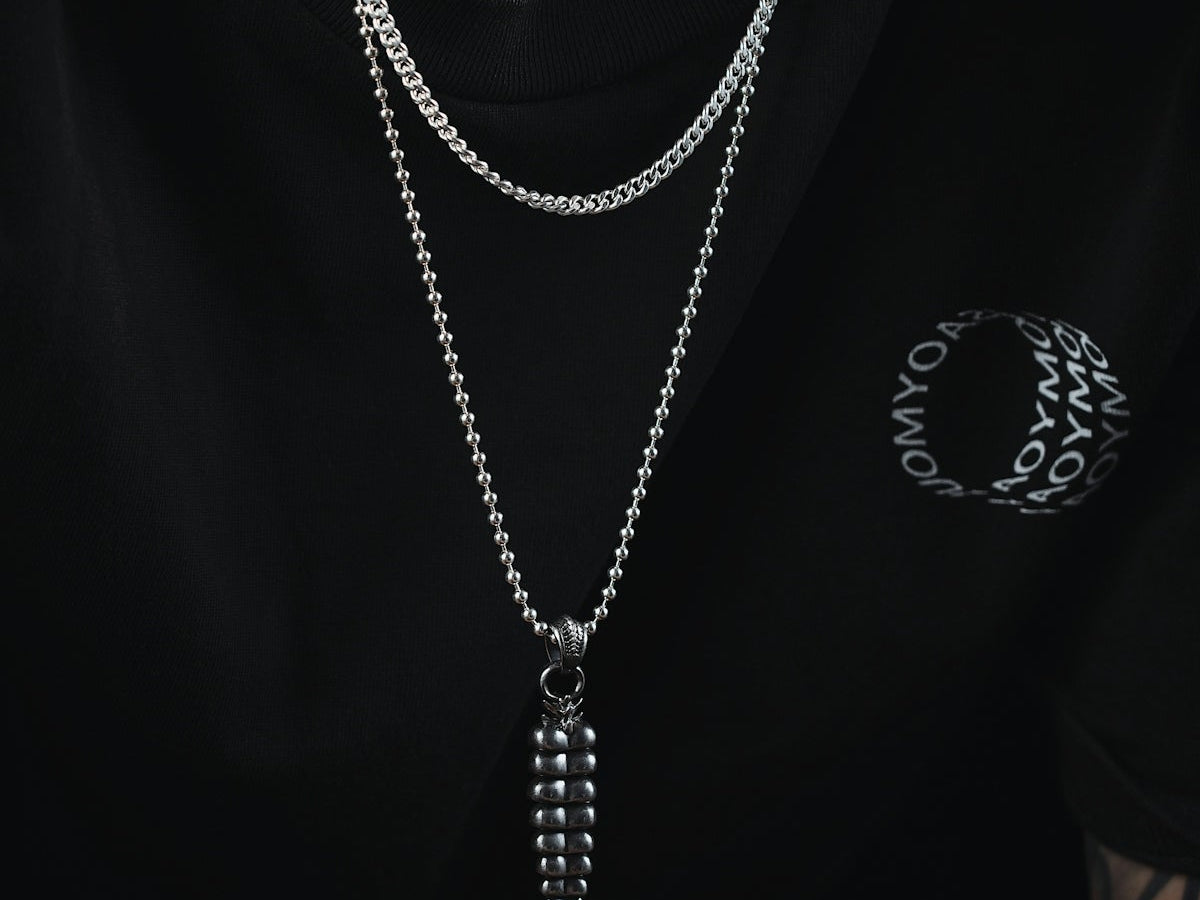 a man wearing a black shirt and a silver chain