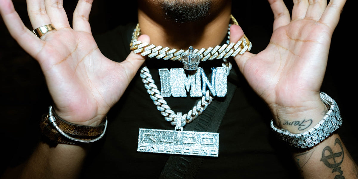 a man holding his hands up with a chain around his neck