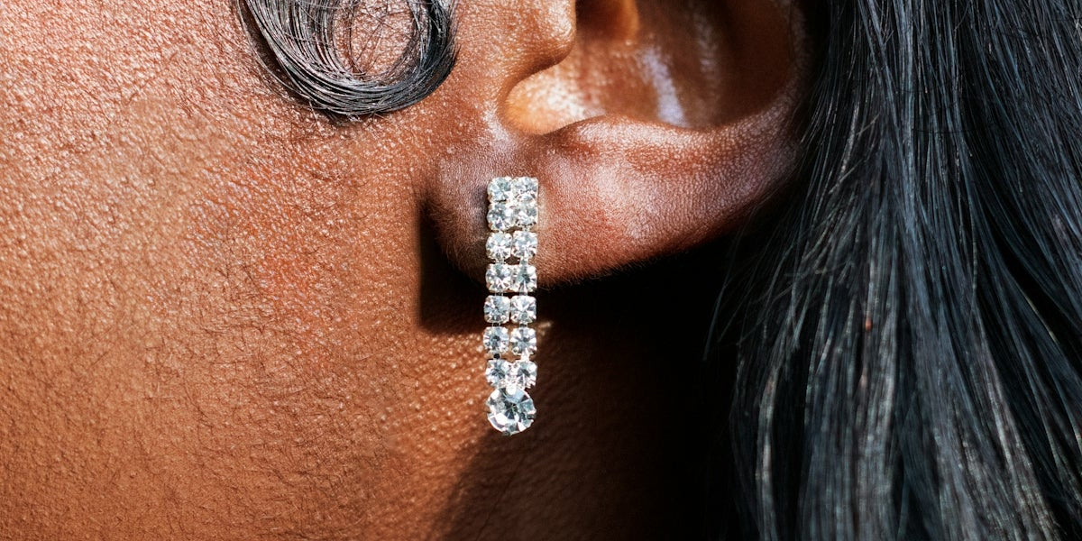 a close up of a person wearing a pair of earrings