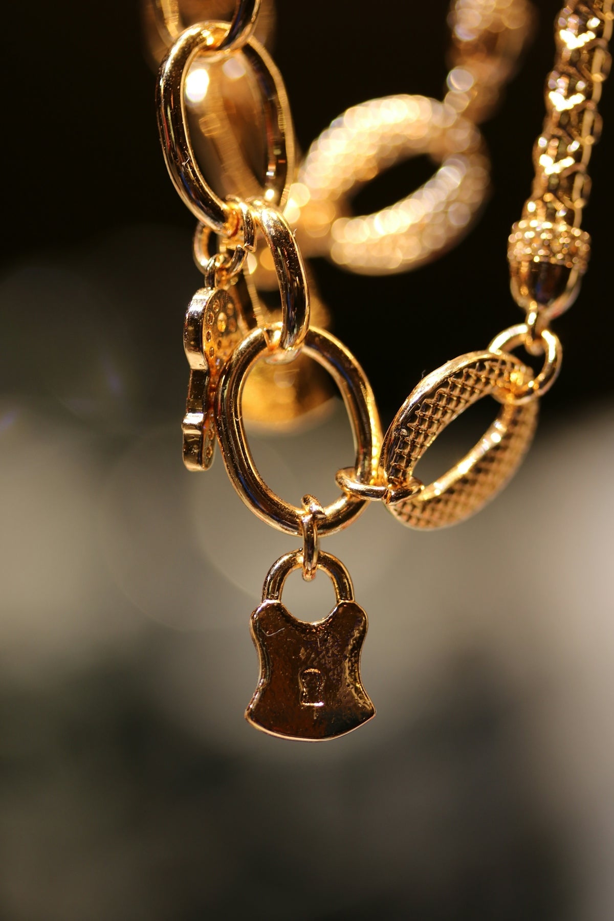 A close up of a gold necklace with a key