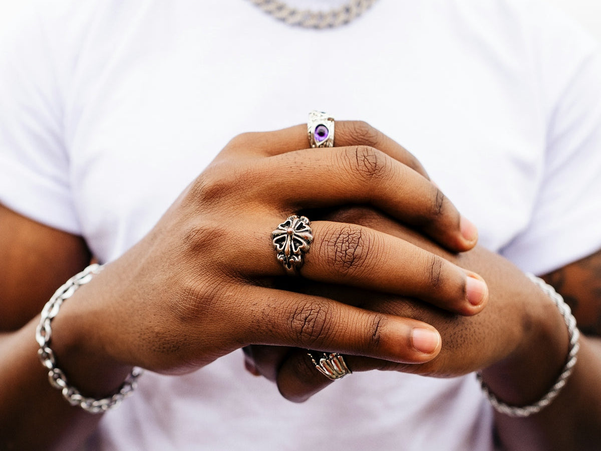A man wearing a white t - shirt is holding his hands together