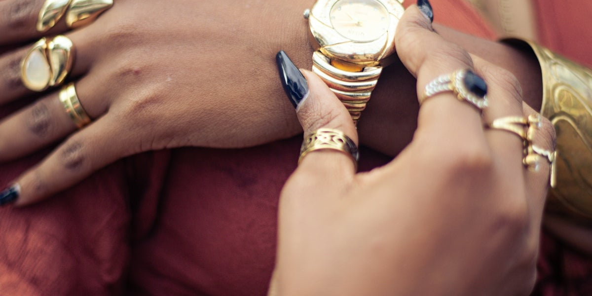 Woman shows off jewelry, checking her wristwatch.