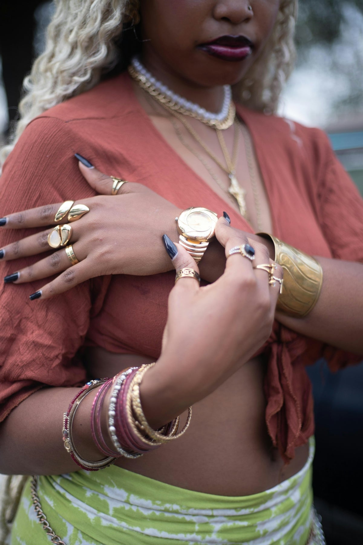 Woman with jewelry checks her wristwatch.
