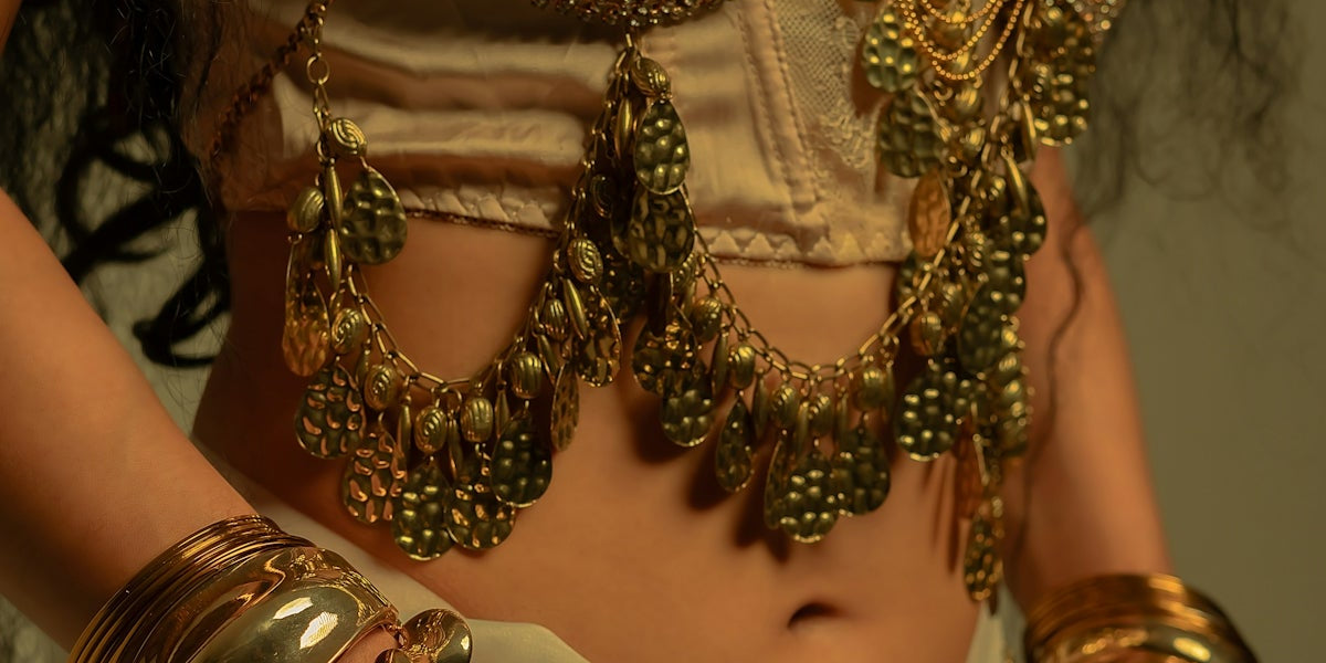 Woman adorned with ornate gold jewelry and costume.