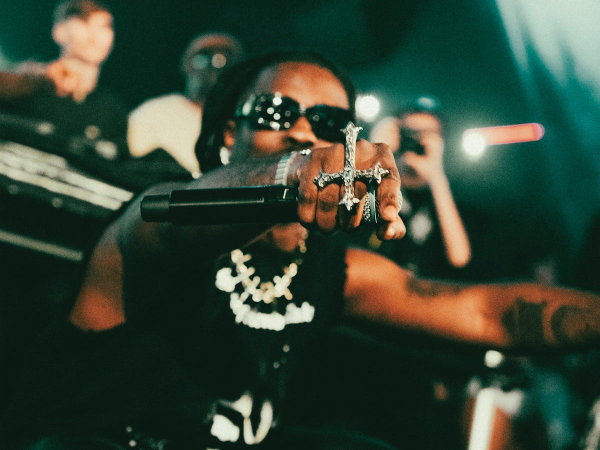Rapper performing on stage with a microphone.